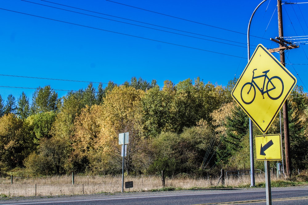 a yellow street sign sitting on the side of a road