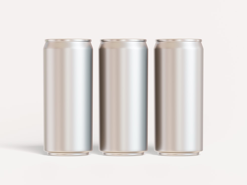 Tres latas de refresco sobre fondo blanco
