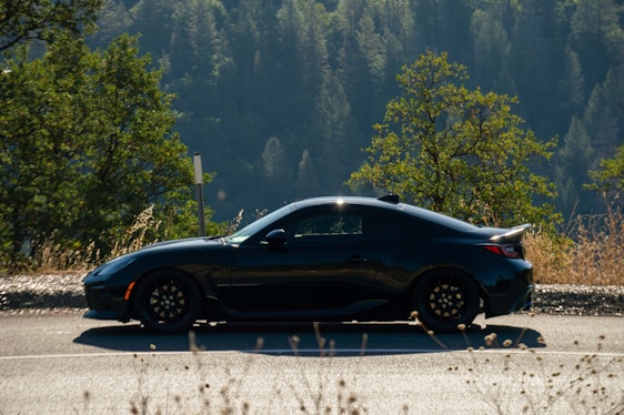 A sleek car parked on a scenic road, showcasing its stylish design.