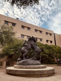 a statue of a man riding a horse in front of a building