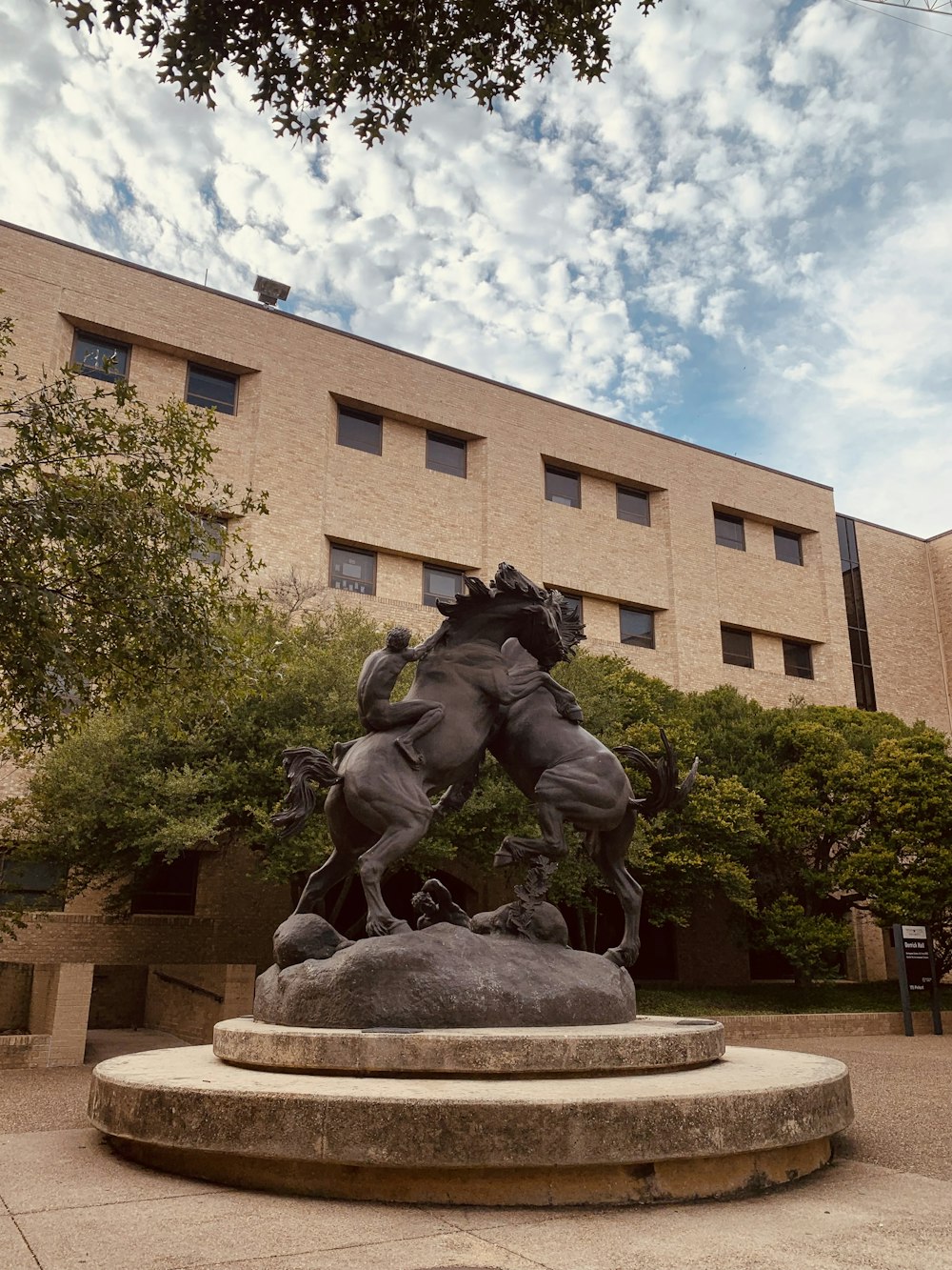 a statue of a man riding a horse in front of a building