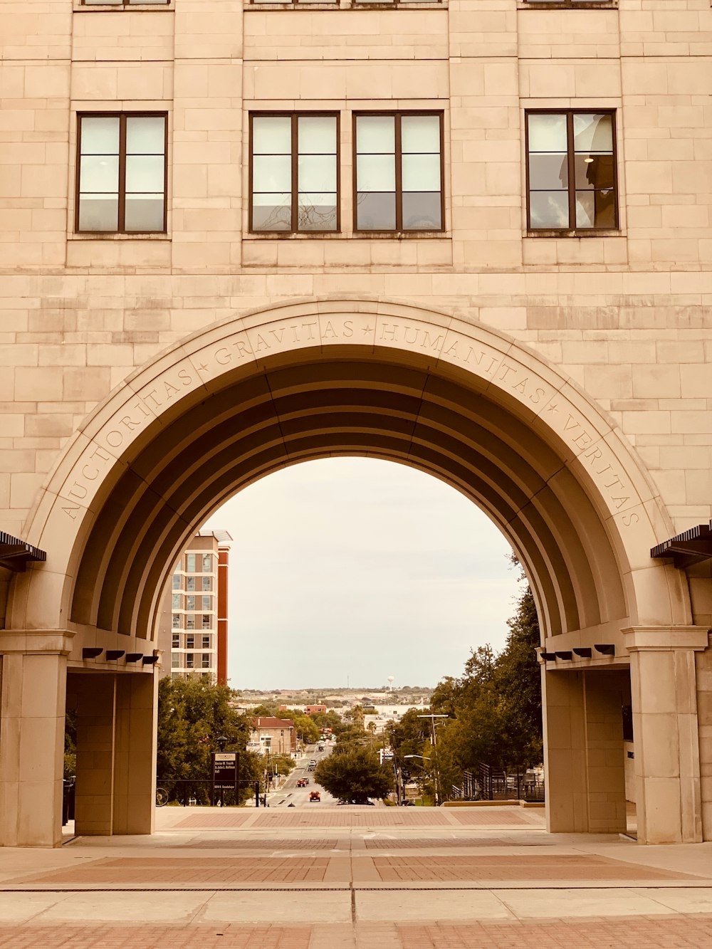 a large stone arch with a clock tower in the background