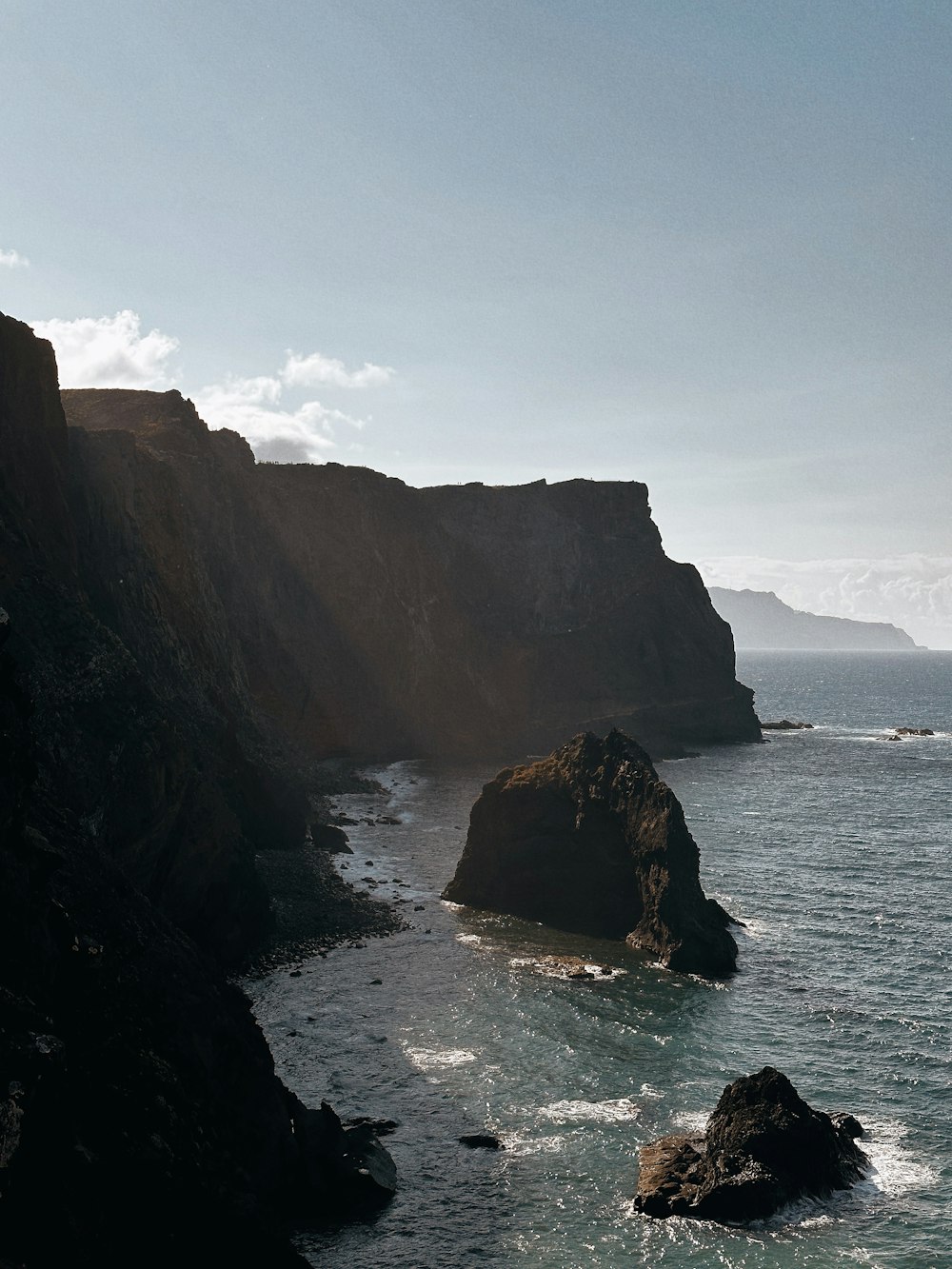 a large body of water next to a rocky cliff