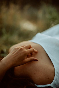 A close-up of hands gently resting on a calm belly during a somatic therapy session.