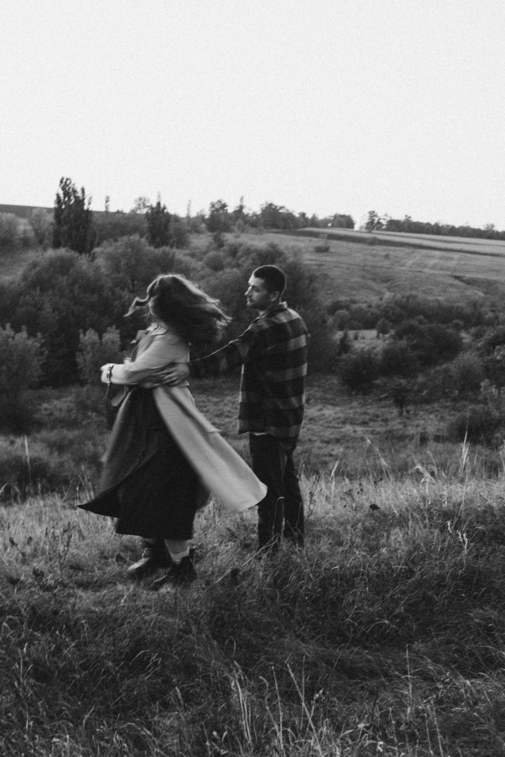 a man and a woman standing in a field