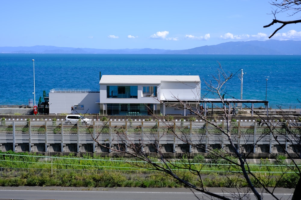 a house sitting on the side of a road next to the ocean