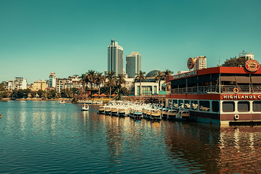 a river filled with lots of boats next to tall buildings