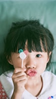 Close-up of a colorful Mickey-shaped ice cream treat held by a smiling child.