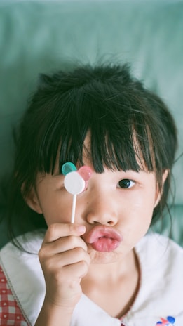 Close-up of a child’s excited face holding a Mickey Mouse balloon.