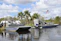 A happy boat owner shaking hands with a marine technician beside a repaired boat in Islamorada.