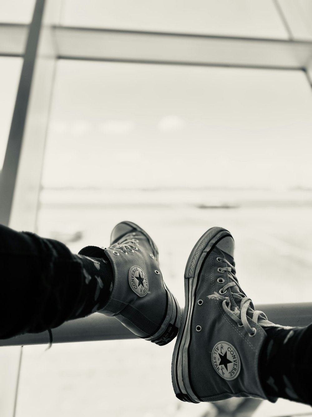 a pair of feet in black and white converse shoes
