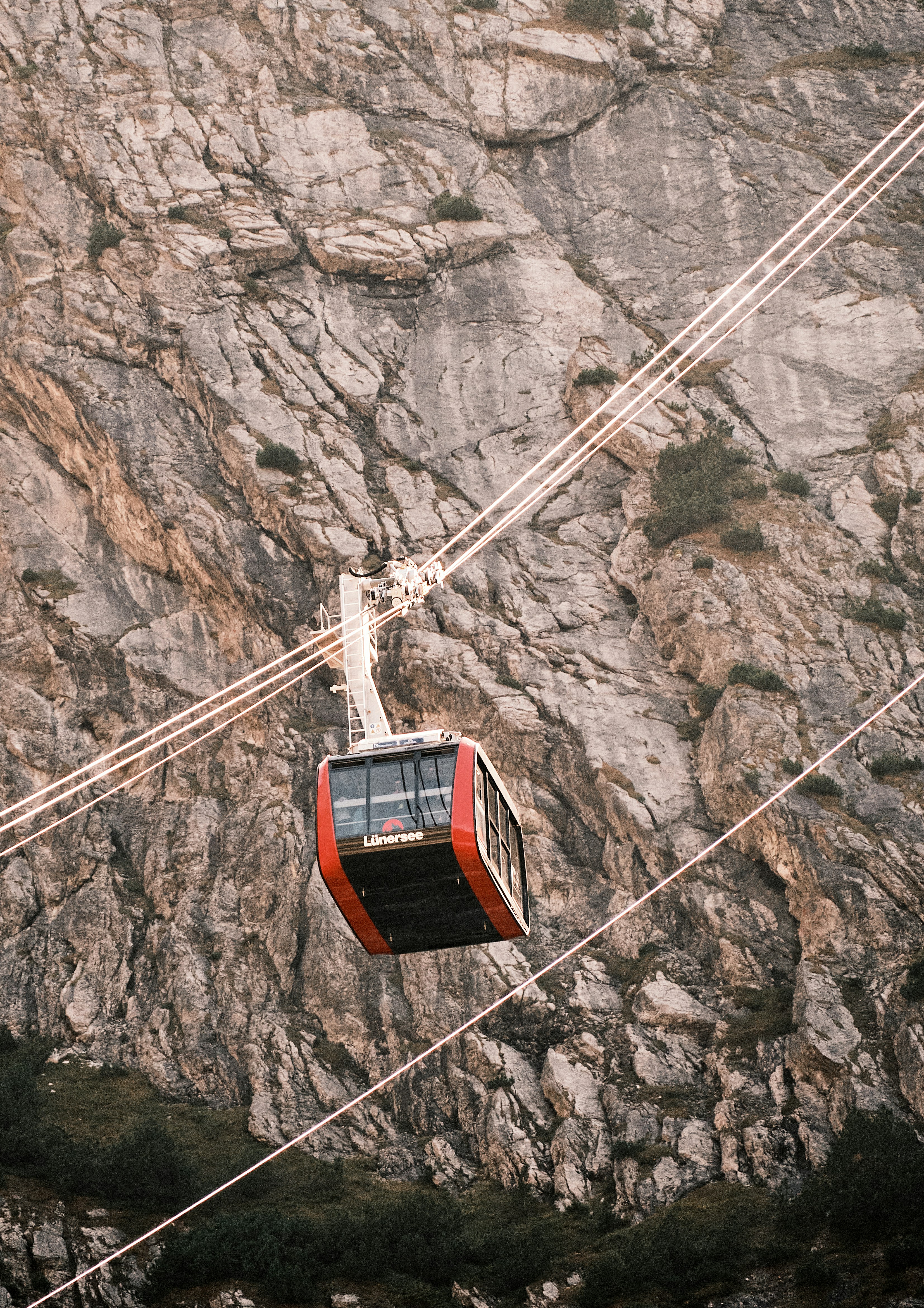 Foto zum Thema Eine rotweiße Seilbahn, die auf einen Berg fährt
