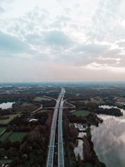 A wide aerial view of a newly constructed African highway cutting through vibrant green landscapes.