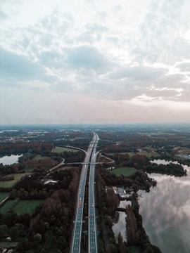 A wide aerial view of a newly constructed African highway cutting through vibrant green landscapes.
