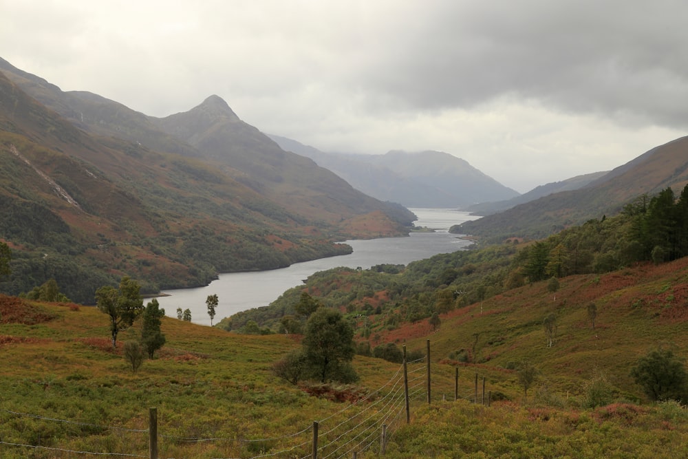 a view of a valley with a body of water in the distance