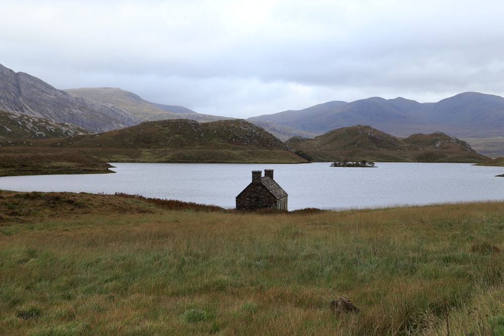 a house in a field with mountains in the background