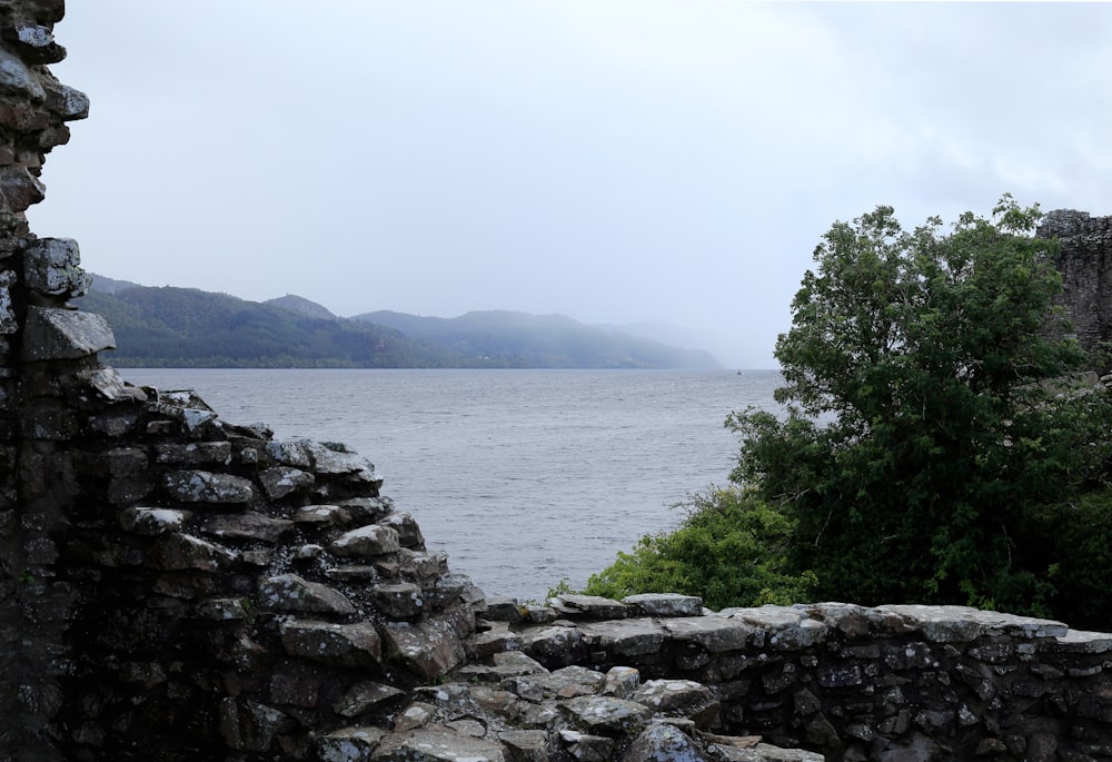a view of a body of water from a stone wall