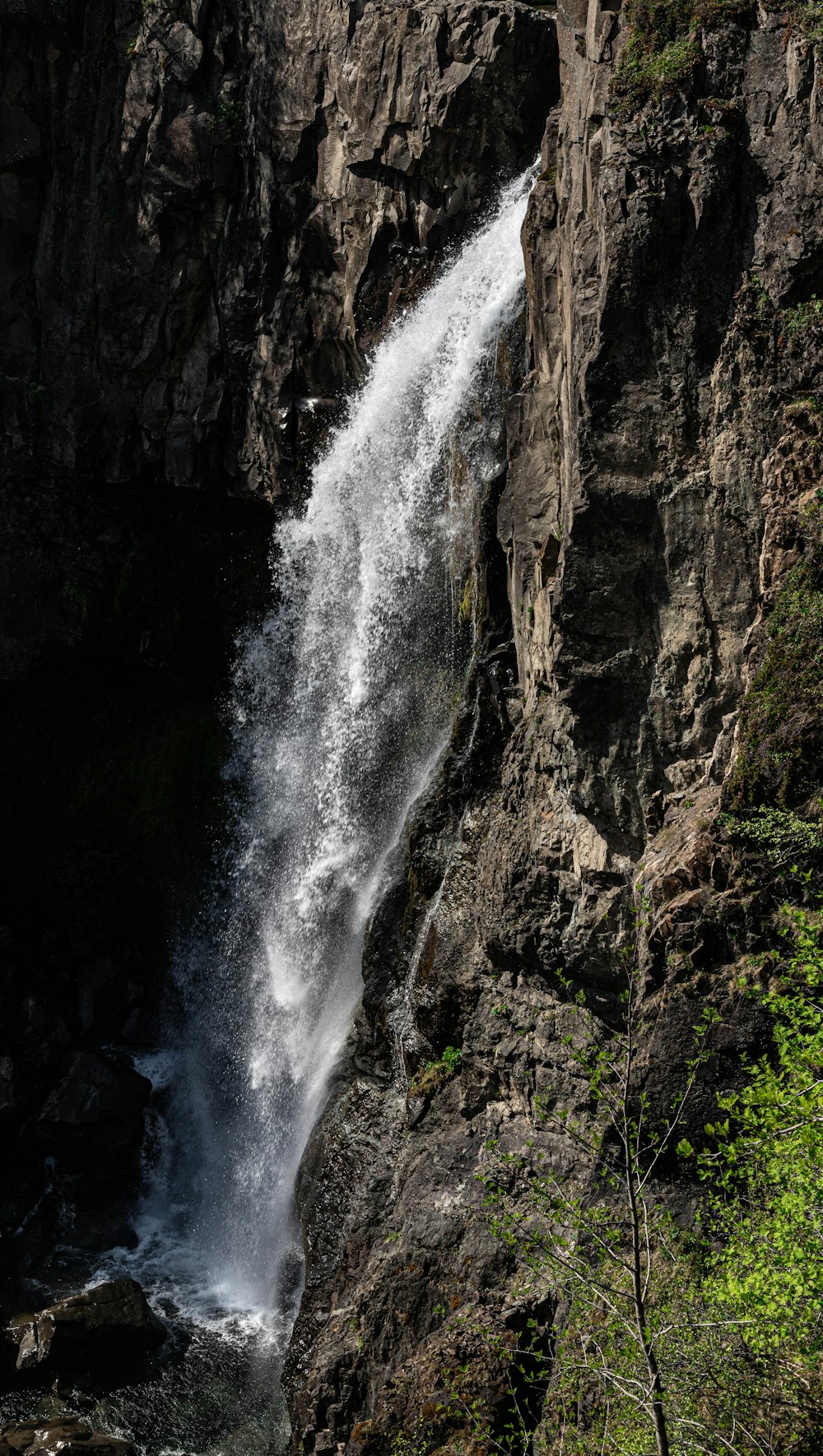 uma cachoeira com um homem parado na frente dela