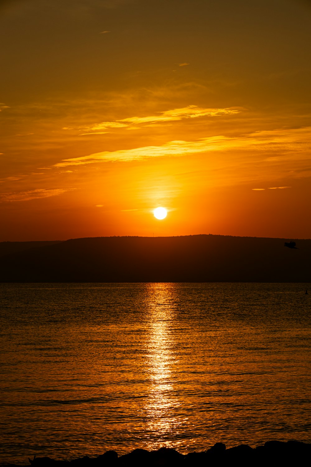 a large body of water with a sunset in the background