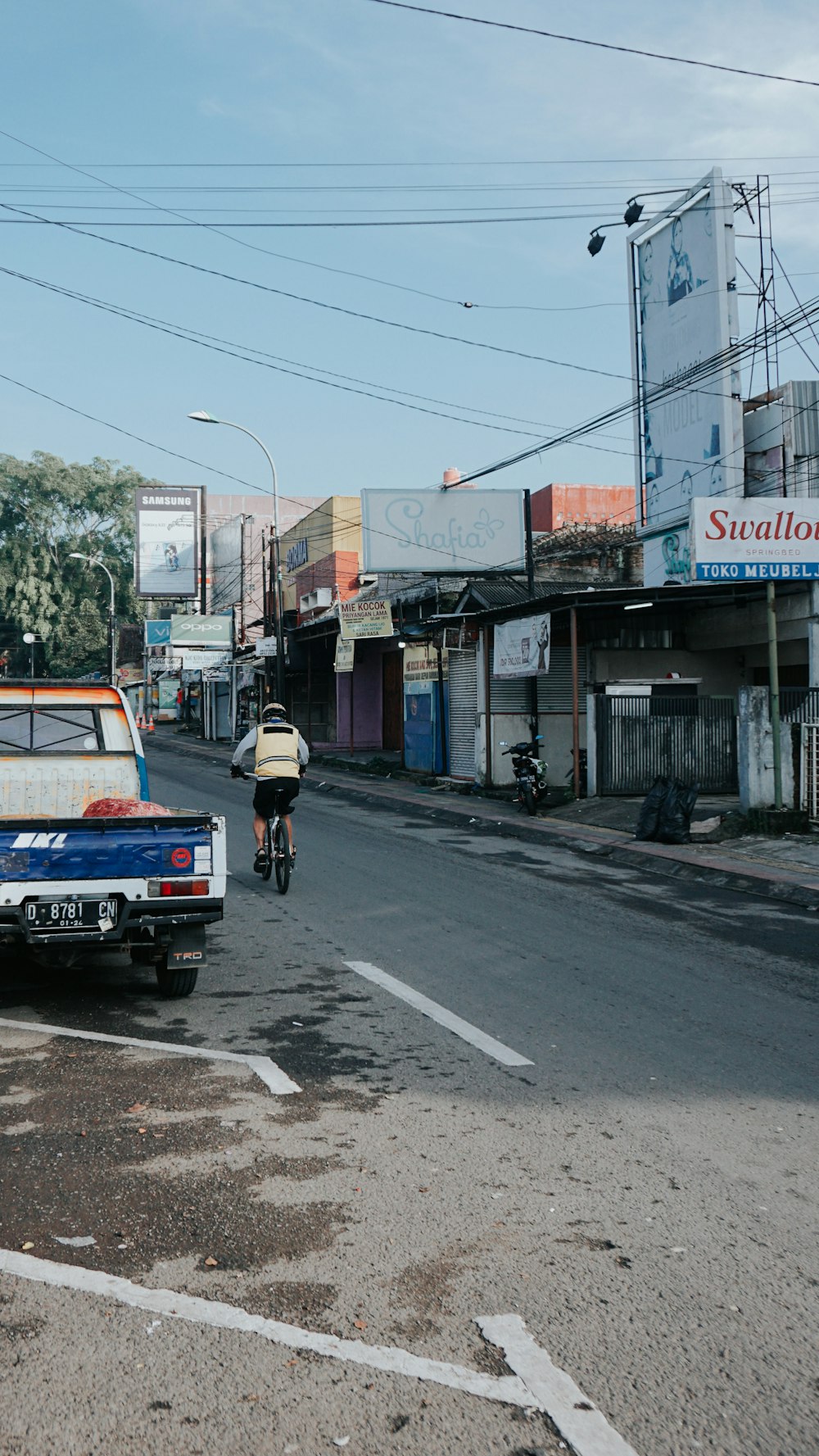 a man riding a bike down a street next to a truck
