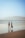 two people walking on a beach holding hands