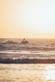 Jet ski slicing through ocean waves with a backdrop of a golden horizon.