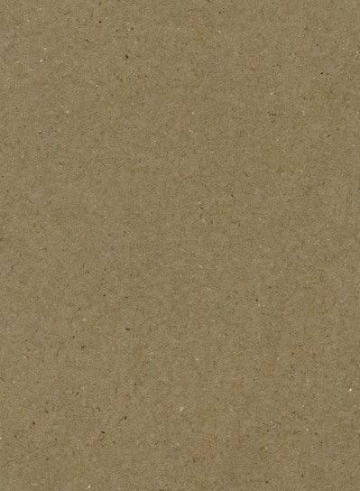 A textured surface with a consistent pattern, resembling recycled or craft paper. The texture includes small specks of various colors, adding to its natural, raw appearance.
