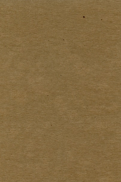 a brown piece of cardboard with a black dot on it