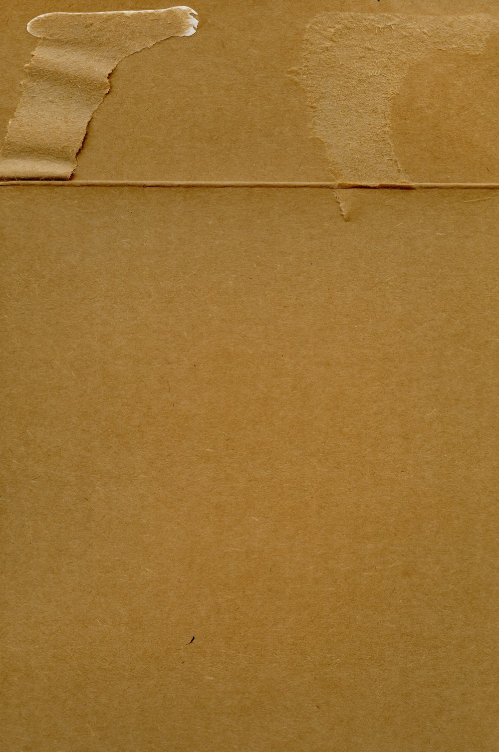 a piece of brown paper with a torn piece of paper on top of it