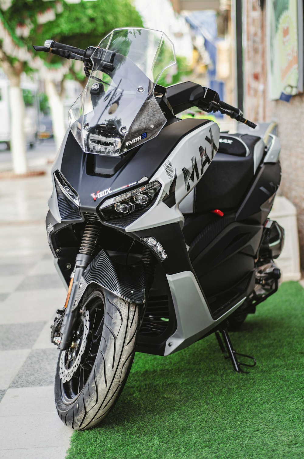 una motocicleta negra y plateada estacionada en lo alto de un campo verde