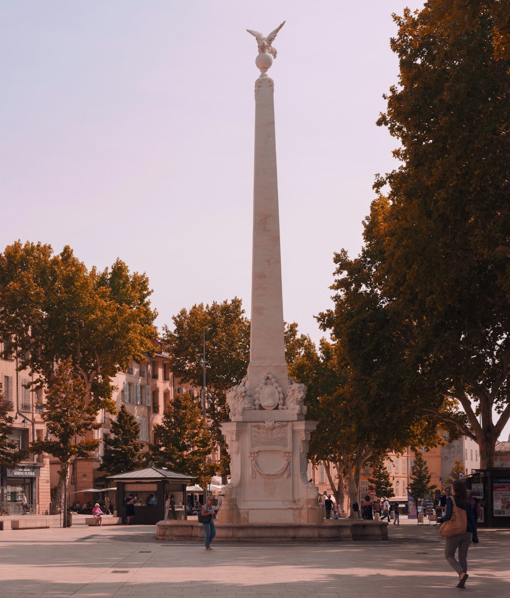 Un monumento alto con una estatua de un pájaro alado en la parte superior