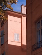 A detailed shot of stucco work on an exterior wall under bright Caribbean sunlight.