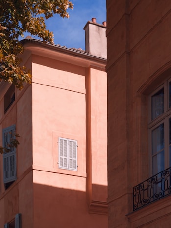 Stucco exterior wall with a textured finish glowing warmly in the afternoon sun.