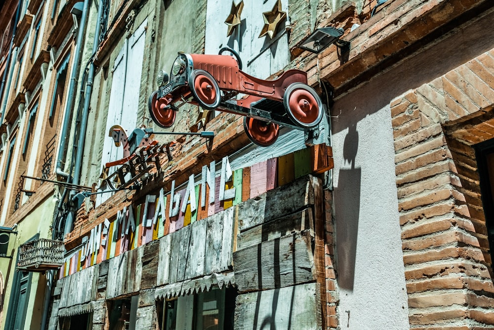 a building with a sign and a bike hanging from it's side