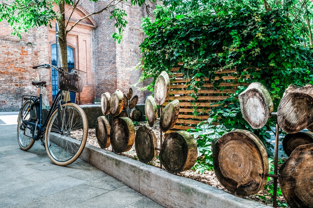 a bike parked next to a bunch of cut up trees