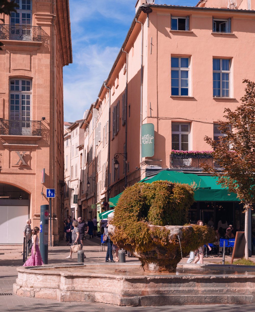 a group of people walking down a street next to tall buildings