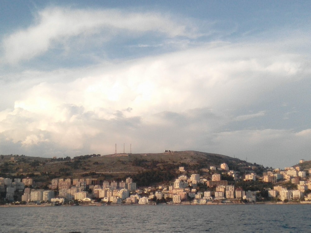 a large body of water with a city on a hill in the background
