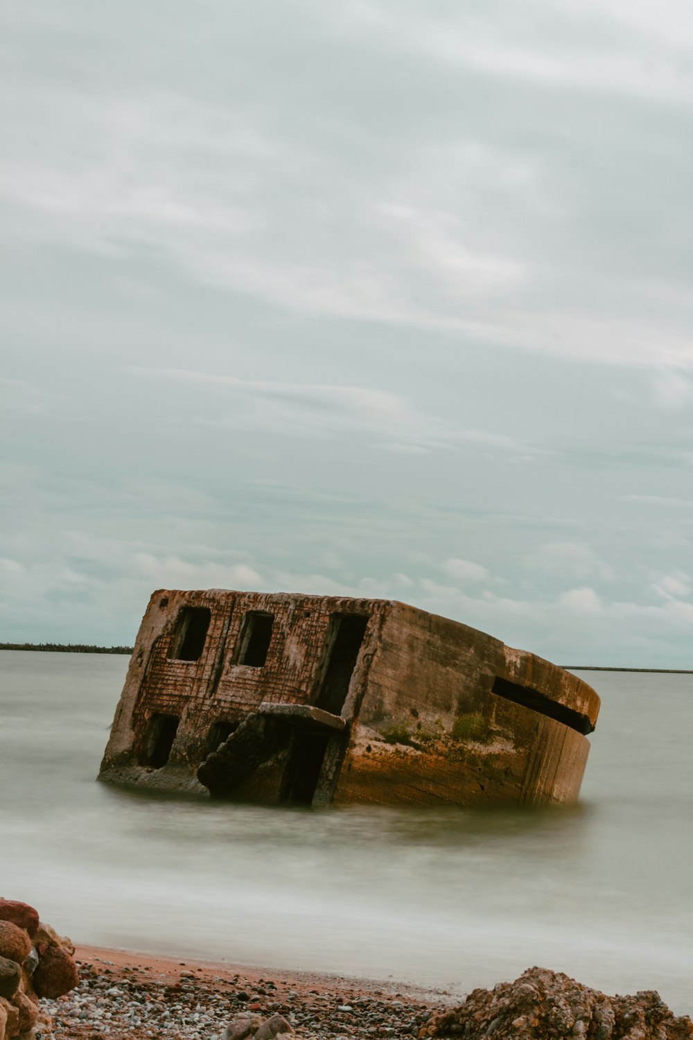 a rusted out boat sitting on top of a body of water