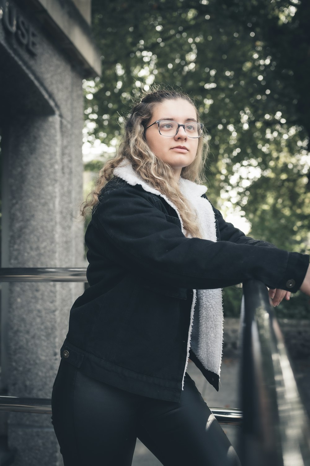 a woman wearing glasses and a black jacket