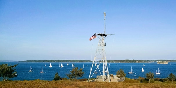 A panoramic view of RP Nauticals campus with maritime flags fluttering and training ships docked nearby.