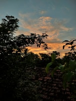 A vibrant acrylic painting showing a sunset over a rustic Sicilian village.