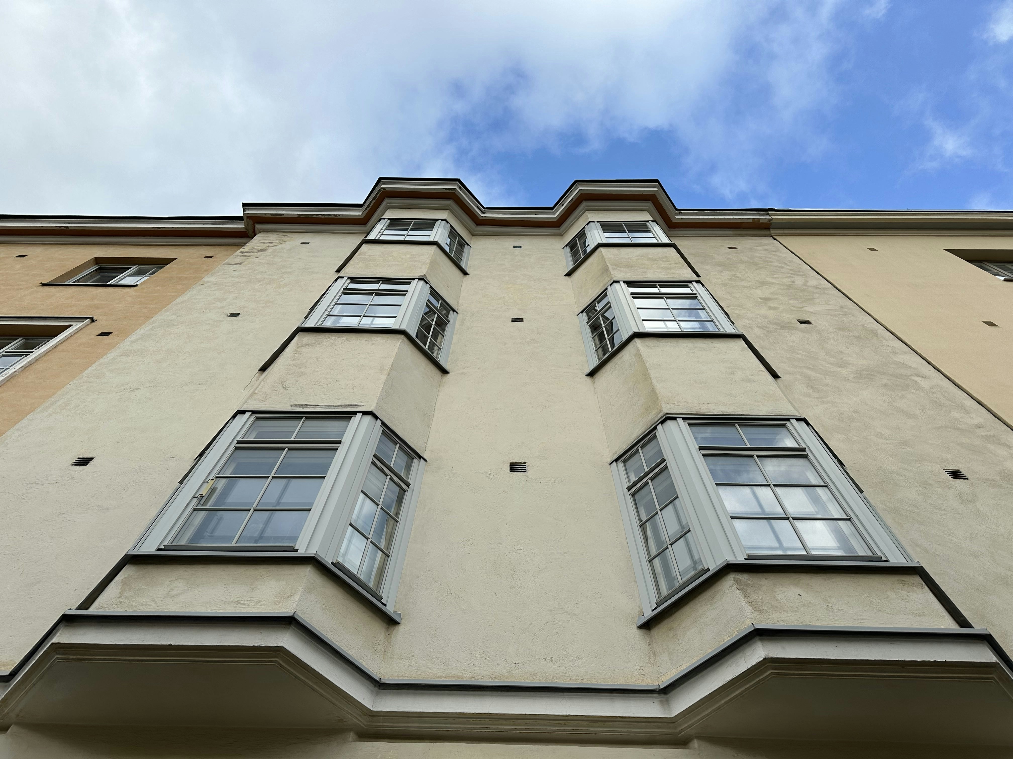 a tall building with many windows and a sky background