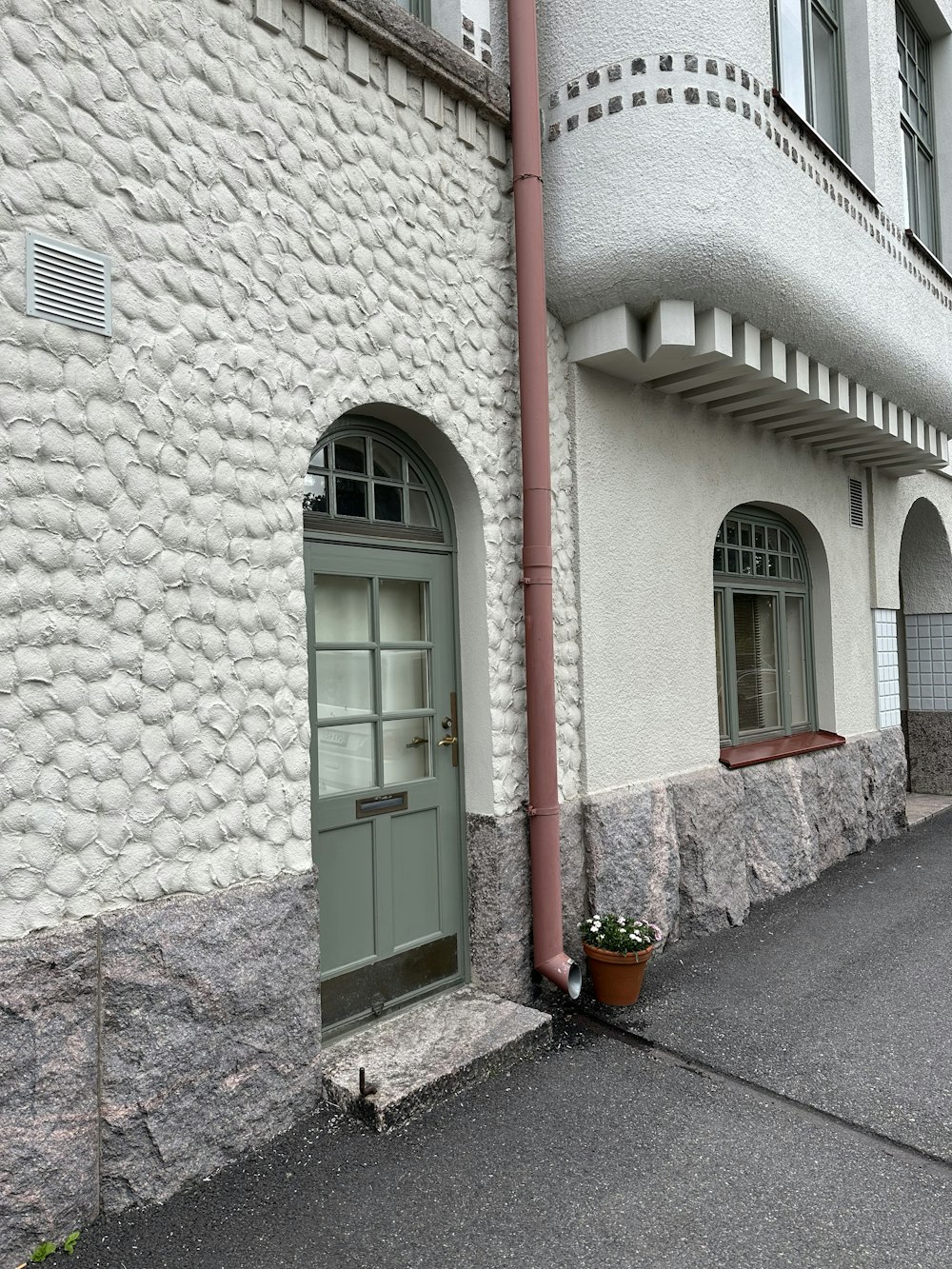 a white building with a green door and window