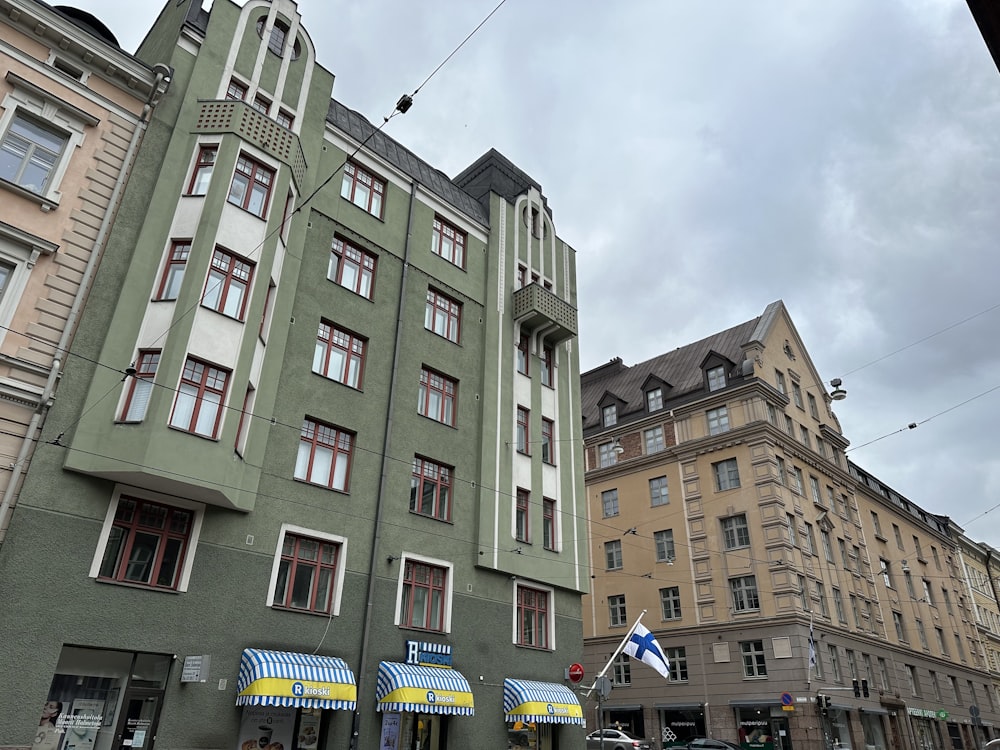 a tall building with many windows next to other buildings