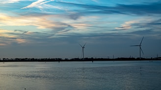 A serene Icelandic landscape with wind turbines powering a modern data center nestled among green hills.