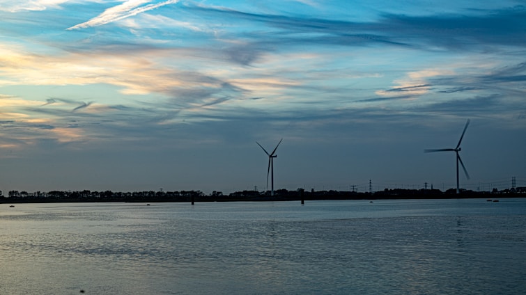 A serene Icelandic landscape with wind turbines powering a modern data center nestled among green hills.
