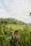A joyful traveler standing by a lush rice terrace in Bali with a bright smile.