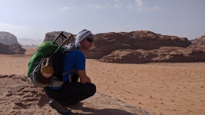 Lifestyle shot of a person hiking in the desert wearing layered green-az apparel.
