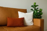 A professional using eco-friendly products on a modern leather couch.