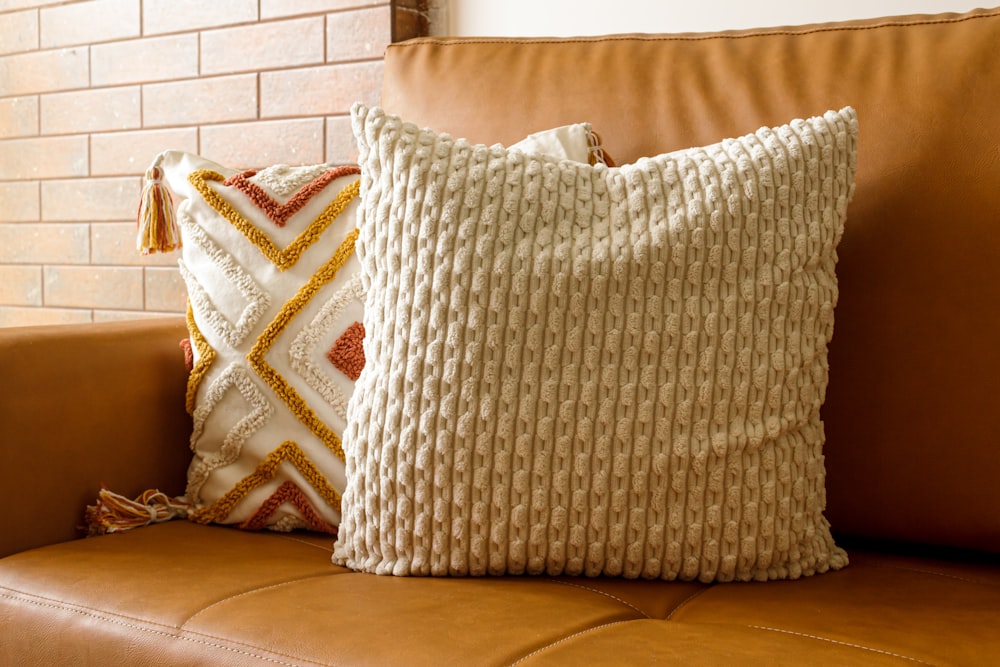 un sofá marrón con dos almohadas